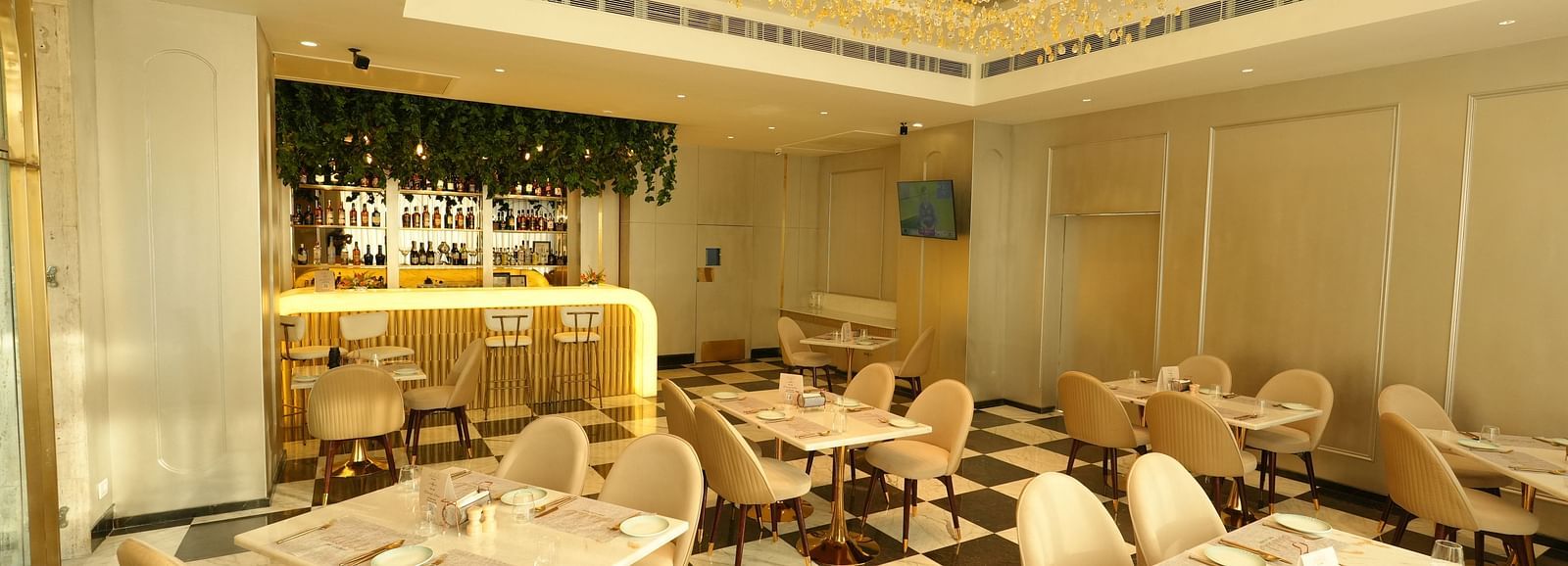 Stylish restaurant interior with modern decor and chandelier lighting at Grand Plaza Lords Inn Jammu.