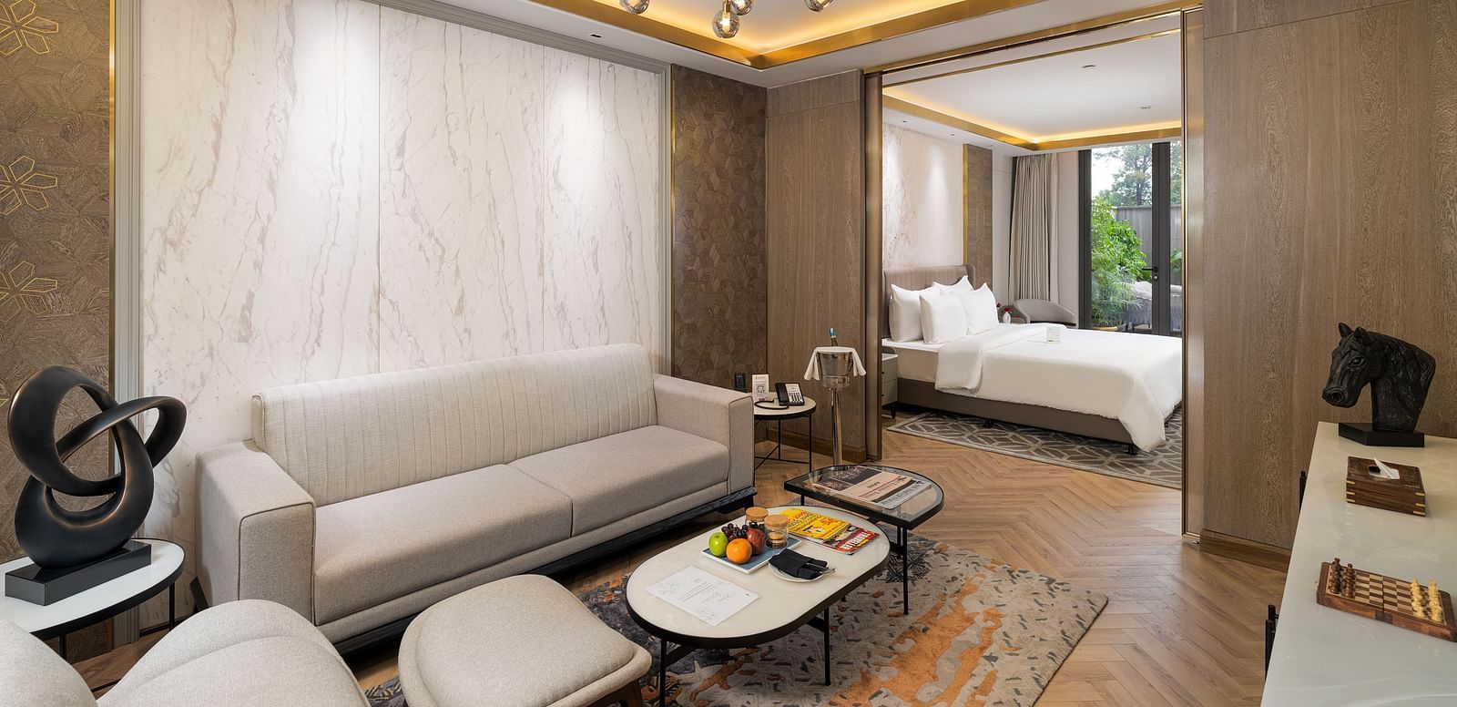 Nirvana Suite living area with a stylish sofa, a chic coffee table, and an open view into the spacious bedroom - Nirvana Luxury Hotel, Ludhiana