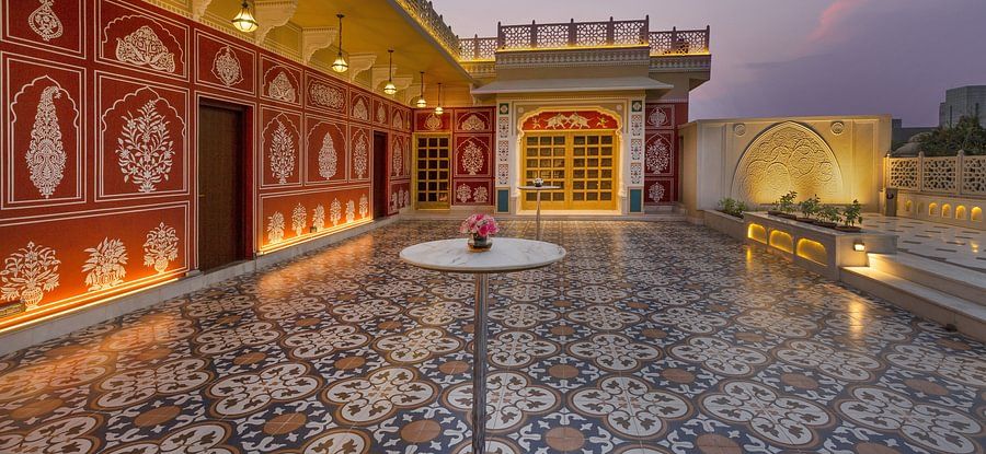 Ornate rooftop terrace with patterned tiles, decorated walls, and soft evening light - Heritage Village Resorts & Spa.