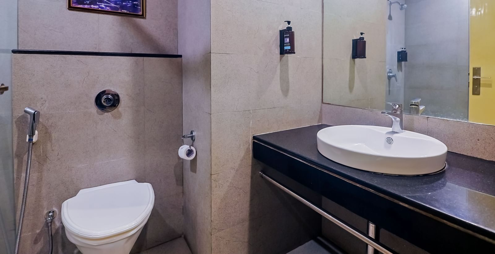 Modern washroom with mirror, sink, and shower at Max Hotel Prayagraj.