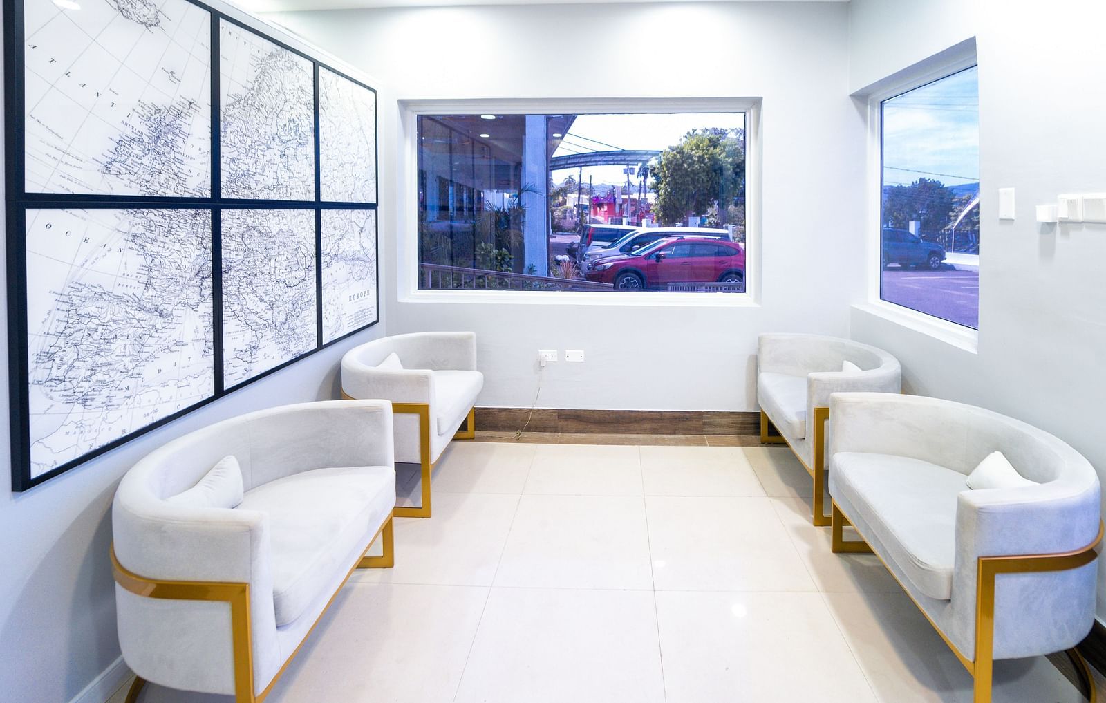 An image of a travel agency with white sofas and a wall-mounted representing the world map - Hotel 39, Jamaica (Montego Bay)