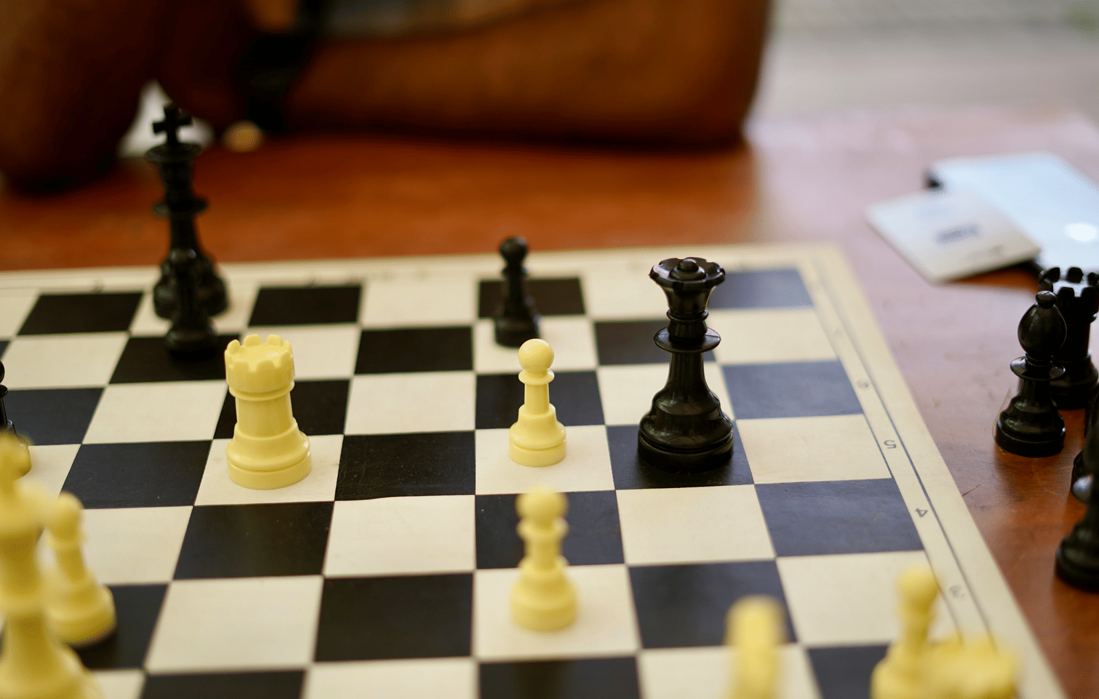 A close-up of a wooden chess board with black and white pieces ready for play.