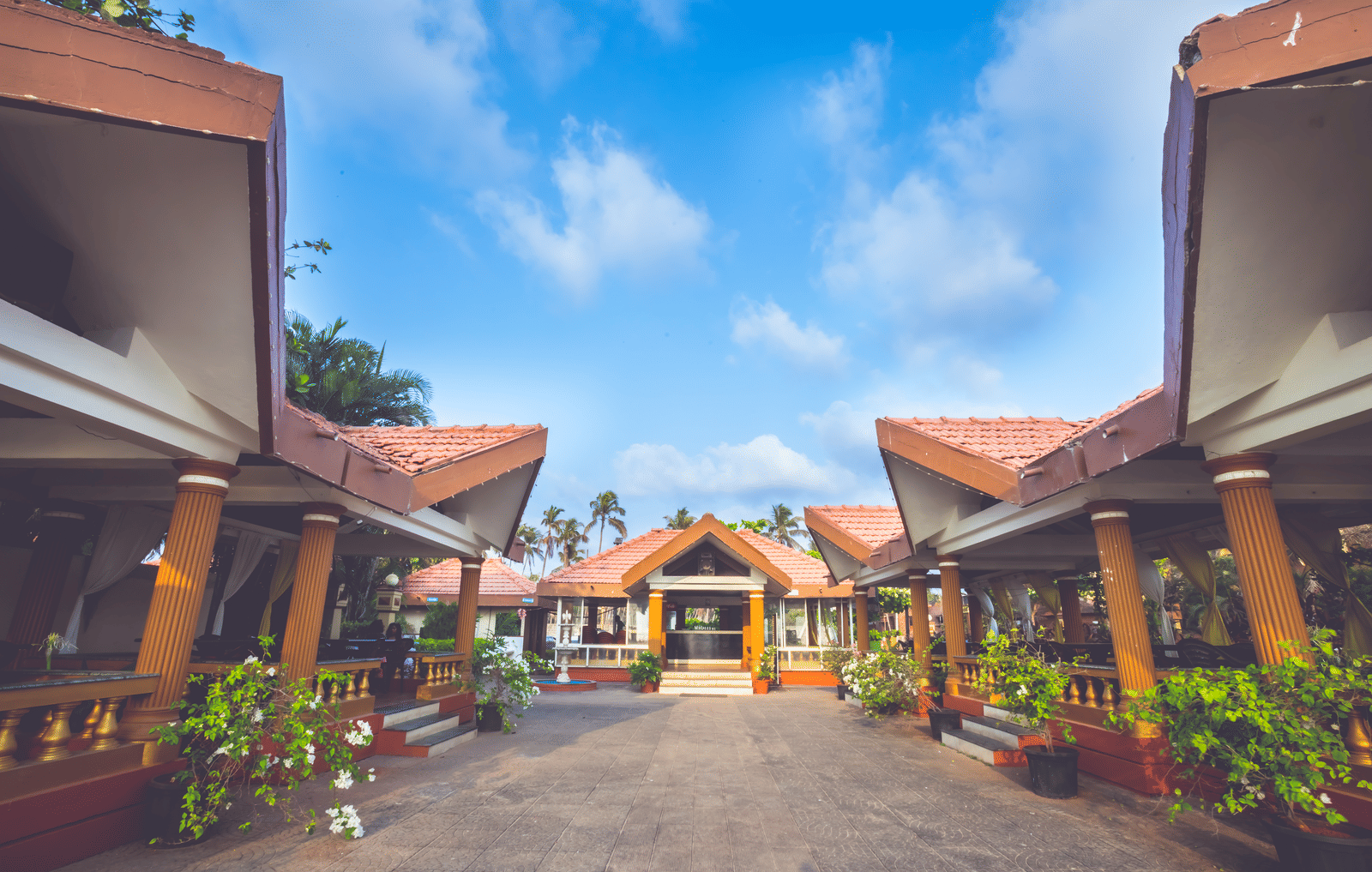A wide view of the exterior of the cottages at Paradise Isle Beach Resort, Udupi during the day