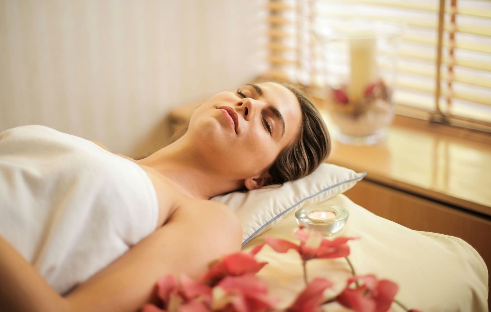 A woman wrapped in a towel laying on a table.