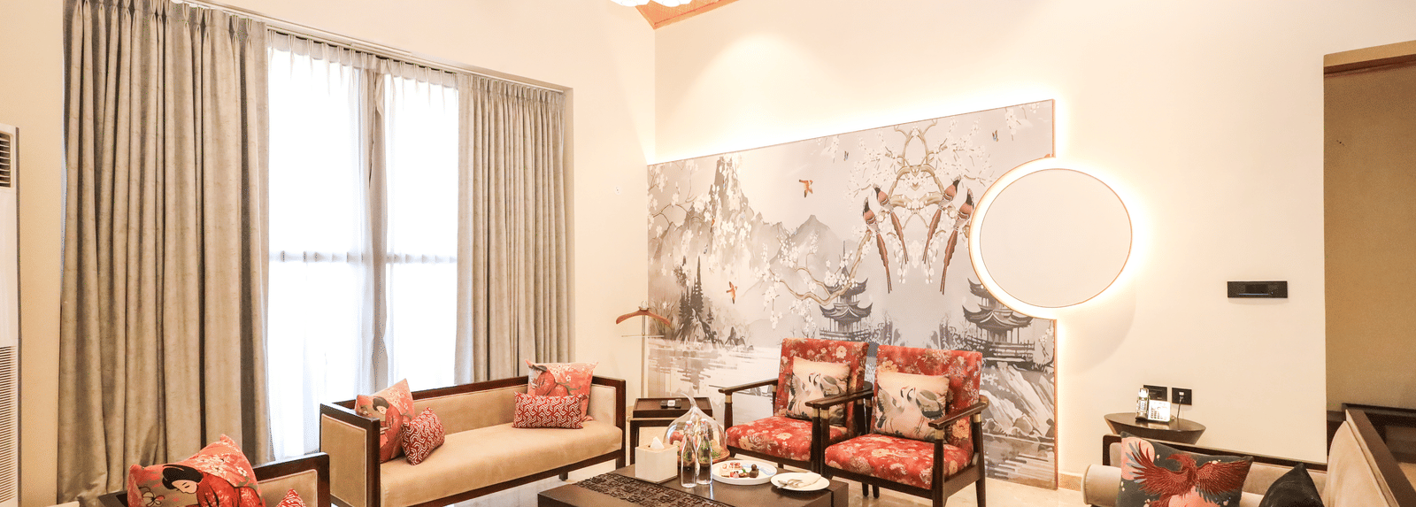 0C7A2614An indoor lounge area with seating, tables and wall art at Ananta Spa and Resort, Jaipur