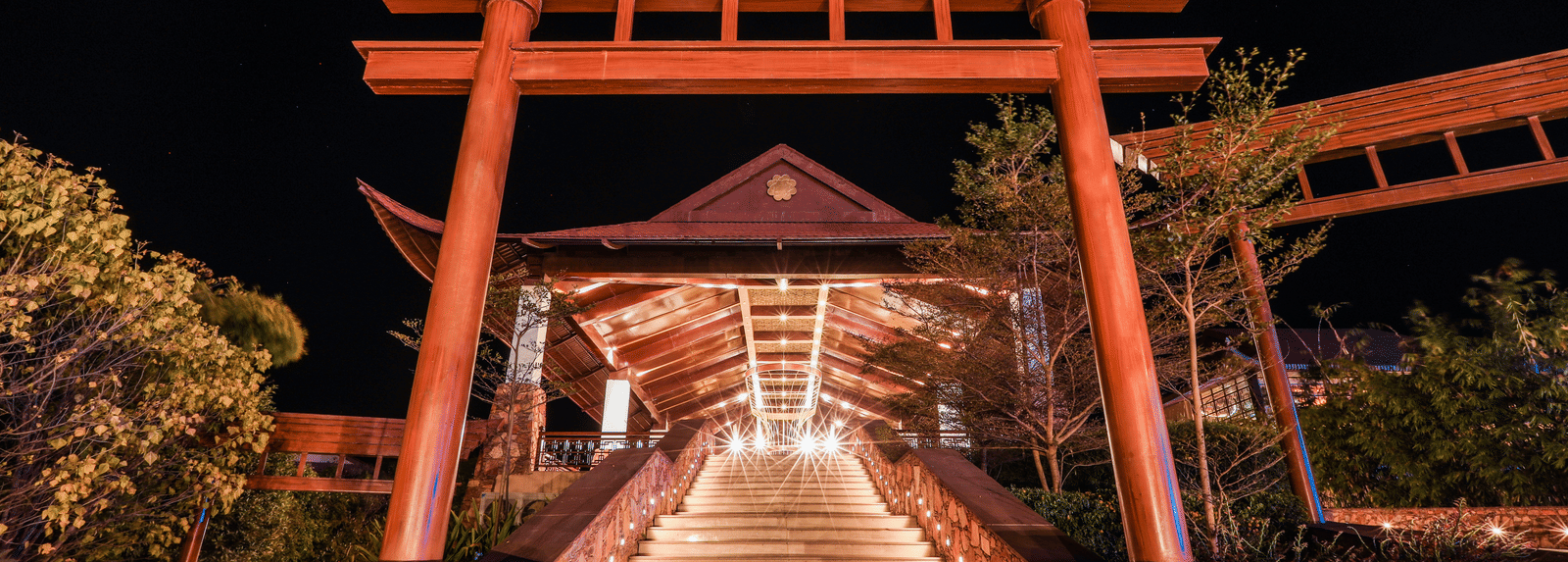 A staircase leading to a large gateway structure with trees on both sides at Ananta Spa and Resort, Jaipur