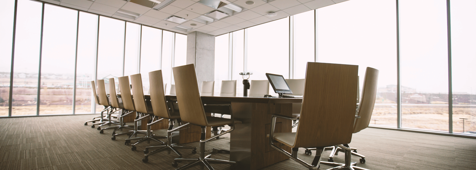 Conference room with floor-to-ceiling windows and office chairs.