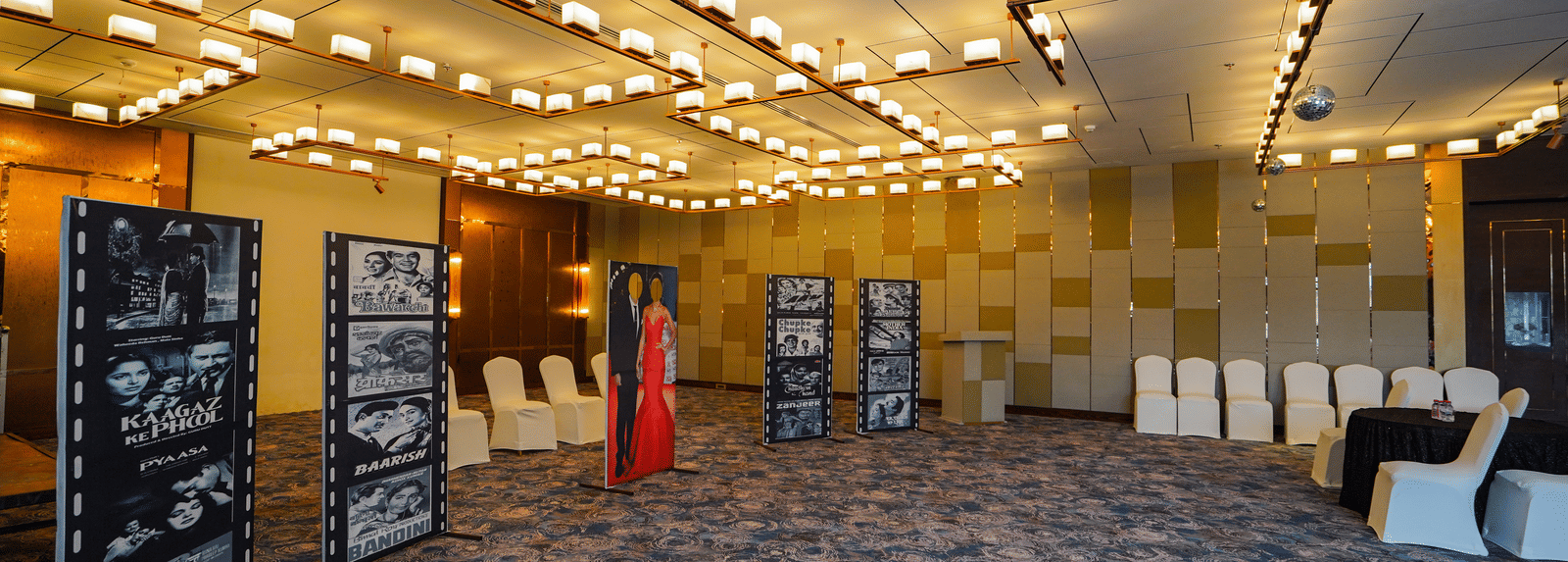 A wide-angle shot of an event space with rows of chairs and a few display boards, indicating a presentation or conference is about to begin.