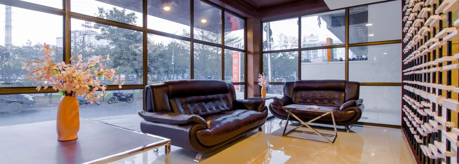 Spacious lounge with leather sofas glass walls natural light and stylish interiors at Swarna's The Capital.