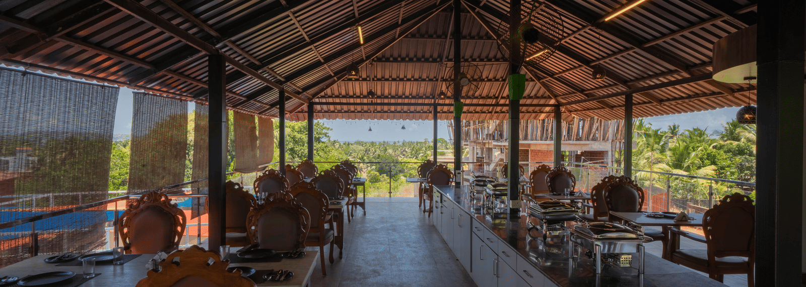 Our restaurant in Goa featuring 4-person seating tables and a buffet counter at the centre - Perfectstayz Koko Maya