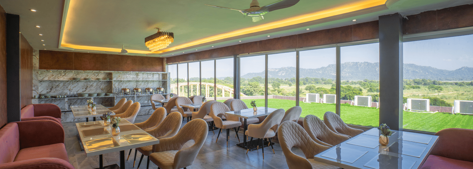 The bright, modern dining area at Sukoon by the Ganges features floor-to-ceiling windows with lovely outdoor views.