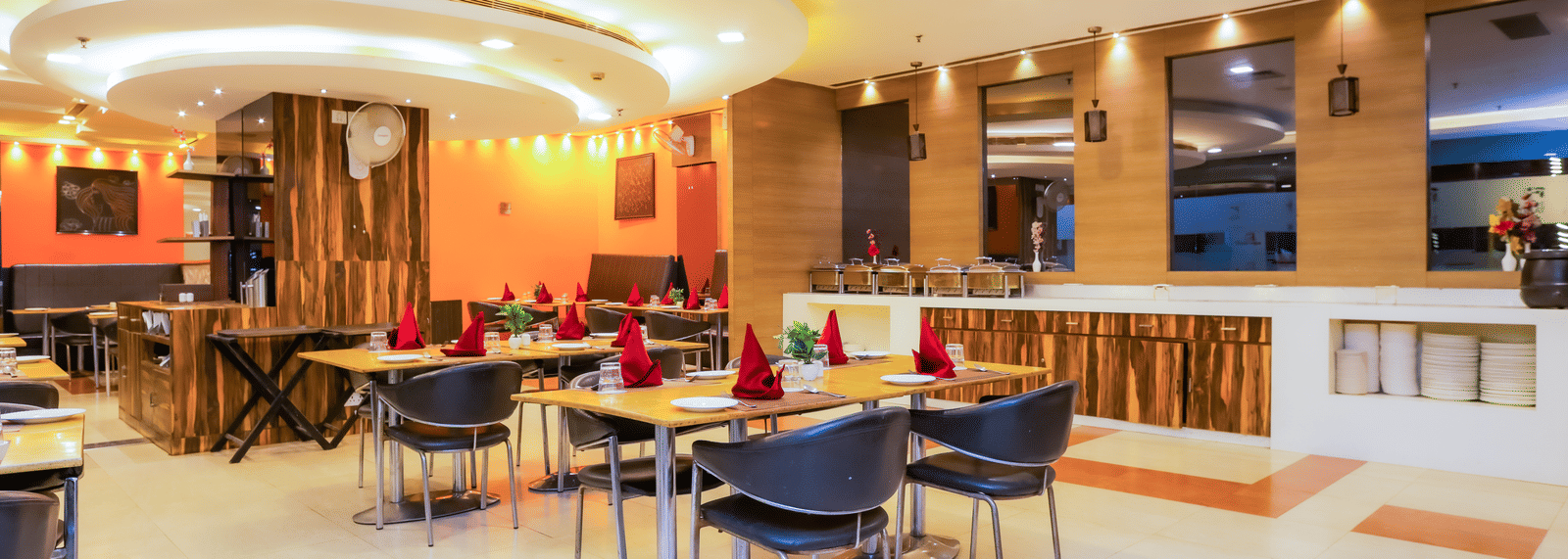 Dining area at Cafe Treat with simple seating arrangement and modern interiors with ambient lighting.