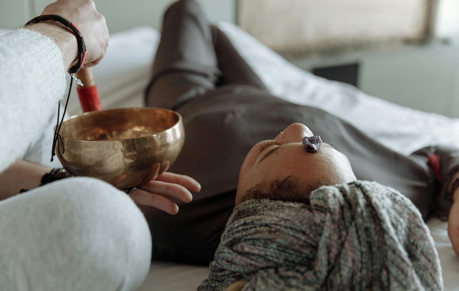 A woman getting sound therapy while laying down relaxing.