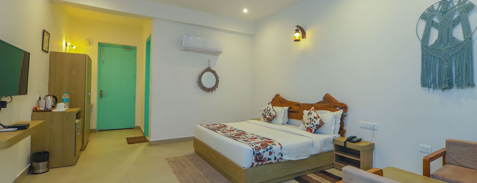 A spacious bedroom at Vedikant Resorts The Mallard Corbett features a bed, seating, and decor in a well-lit setting.