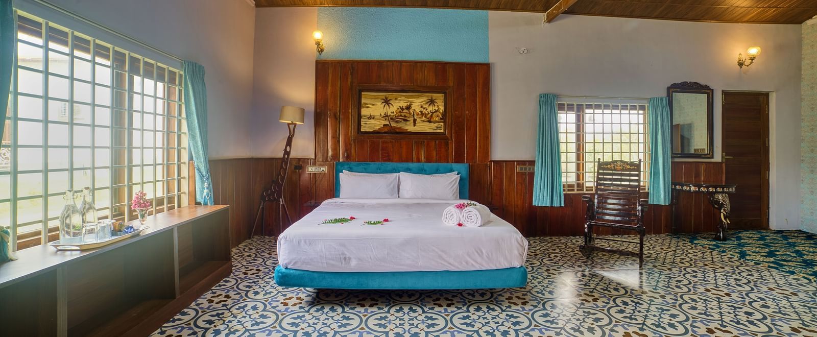  A spacious hotel room with a large bed, patterned tiled floor, wooden ceiling, and a sitting area with a window, bathed in warm light - Vintage Trails by Ilara