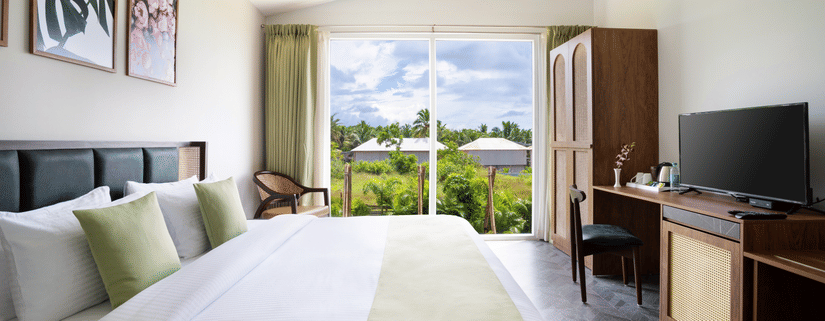 full view image of the bedroom featuring a queen size bed with elegant french windows at the far end with amazing views