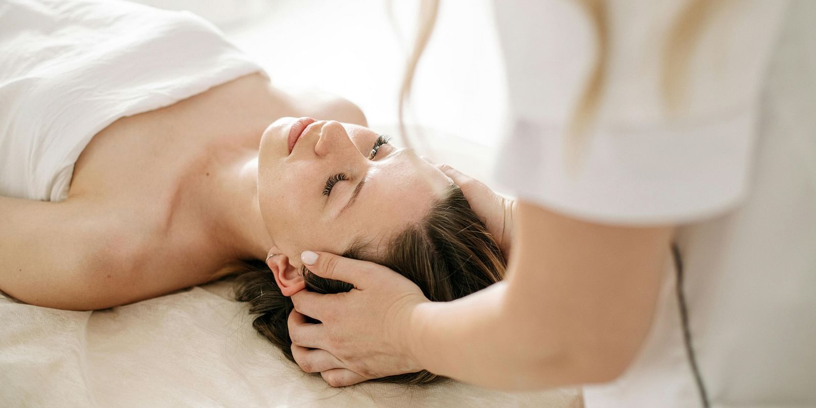 A therapist performing a soothing head massage on a client to promote relaxation.