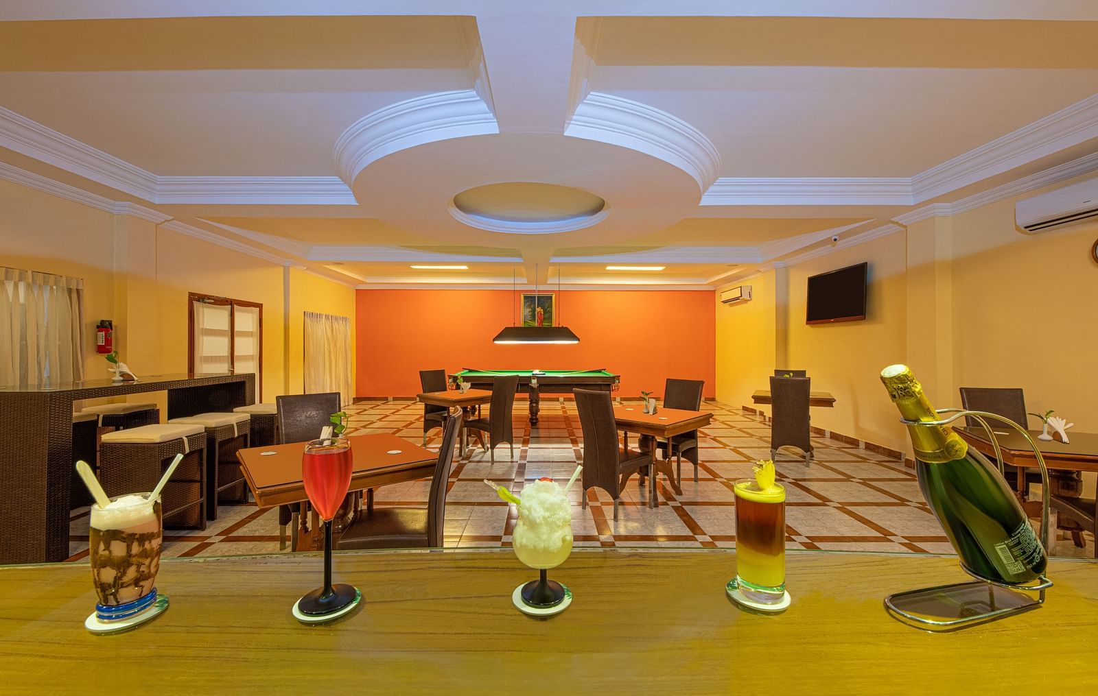 A shot of the dining space featuring different drinks at the table along with seating arrangement - Great Trails Yercaud by GRT Hotels    