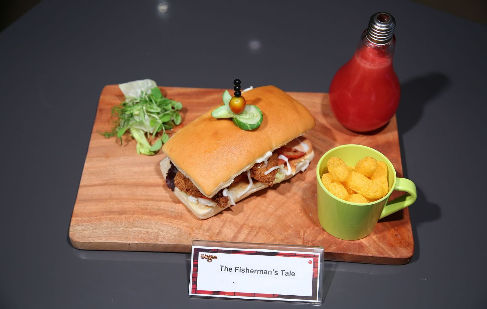 A breakfast platter featuring a toasted sandwich filled with scrambled eggs and vegetables, a side salad, a cup of soup, a bottle of juice, and dipping sauce.