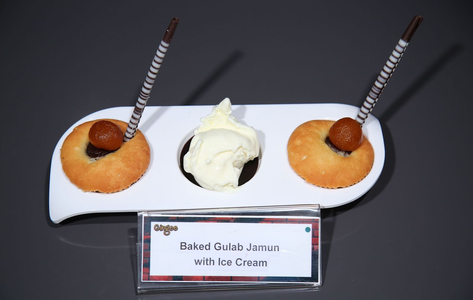 Three round pastries with cherries on top, and a dollop of white cream in the center. Baked Alaska with Ice Cream.