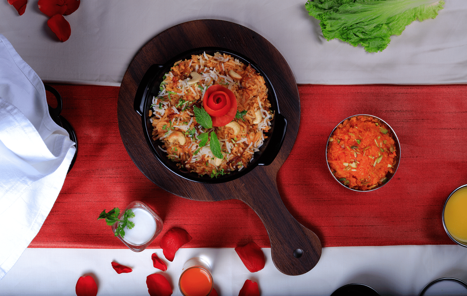 Golden fried rice topped with a red rose and served with a side of red sauce.