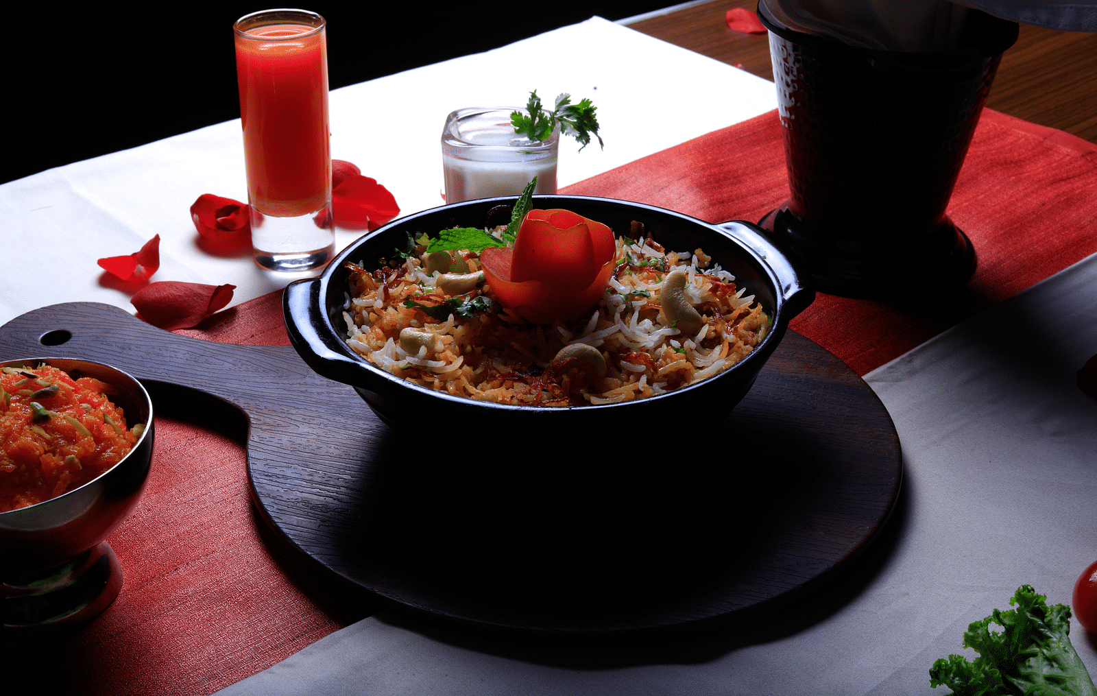 Golden fried rice topped with a red rose and served with a side of red sauce.