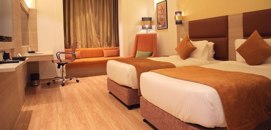 room with twin beds and wooden flooring at best western vrindavan