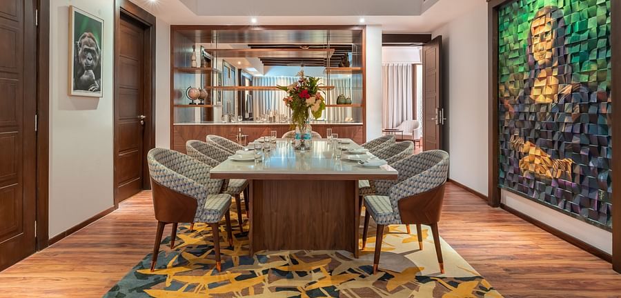 A dining table with chairs and a picture of Mona Lisa on the side at the Grand Suite- The Ananta Udaipur