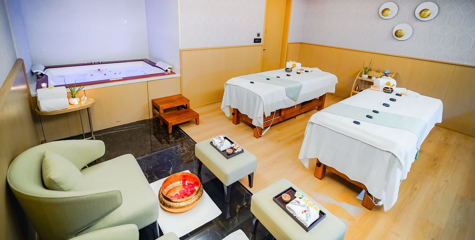 A treatment room in Bodhi Spa in Madurai with comfortable furniture and bath tub to relax in - Grand Madurai by GRT Hotels