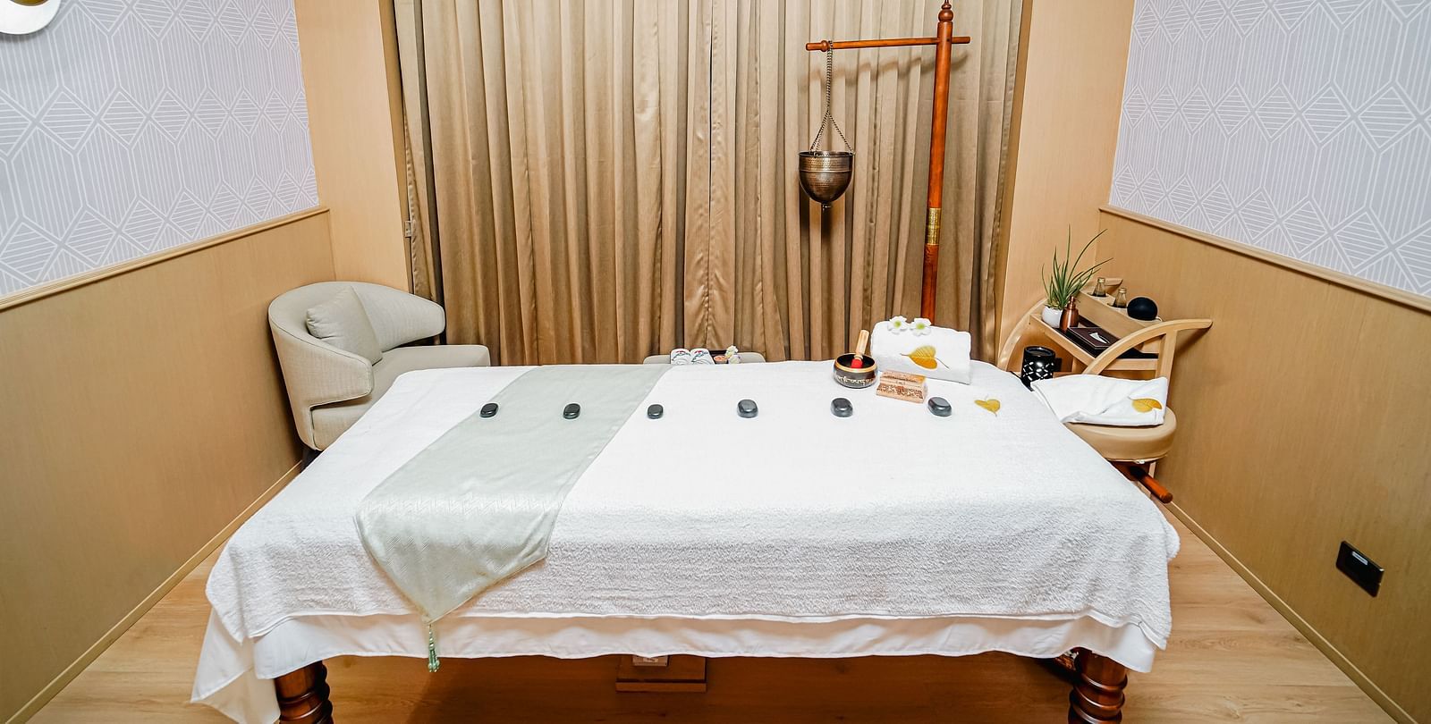 A peaceful Bodhi spa treatment room with a massage table set up for a relaxing experience - Grand Madurai by GRT Hotels