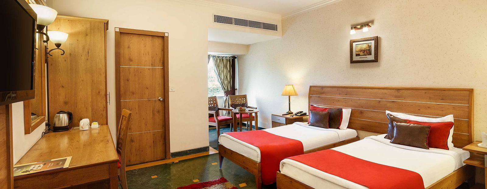 Hotel room with twin beds and a wall-mounted TV.