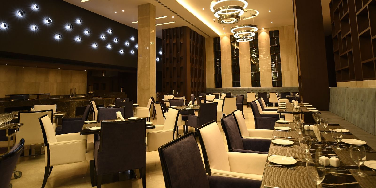  A dining area with cosy lighting, featuring tables set and chairs arranged for guests to savour their meal