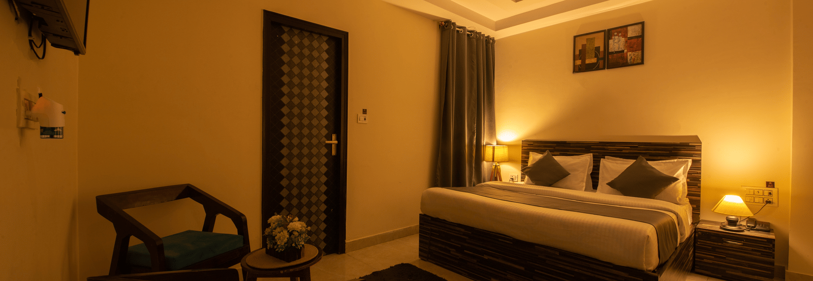 Spacious hotel room with ambient lighting and seating area - Perfectstayz Value Umra Grace, Haridwar