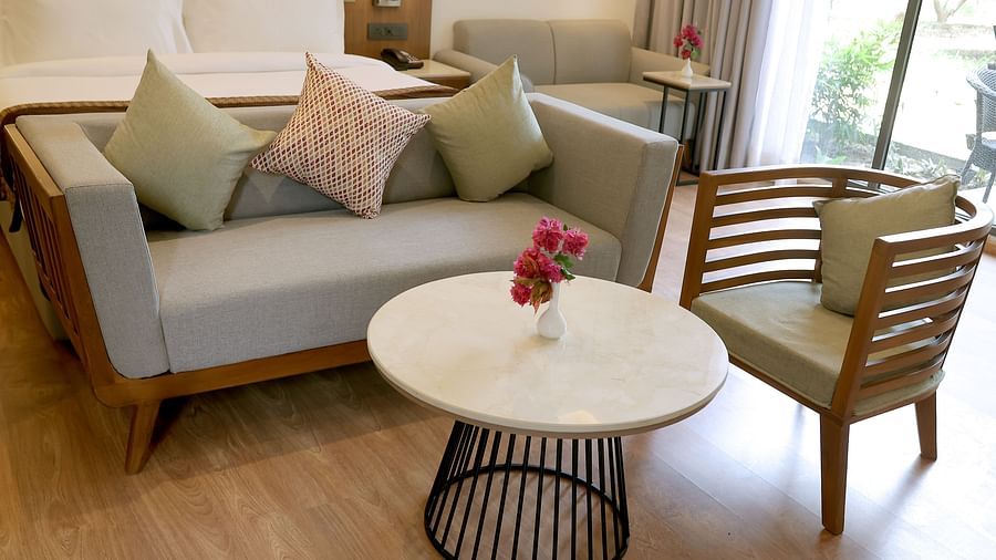Close-up of a stylish seating area with pastel cushions and a round table set with flowers at Wyndham Garden.