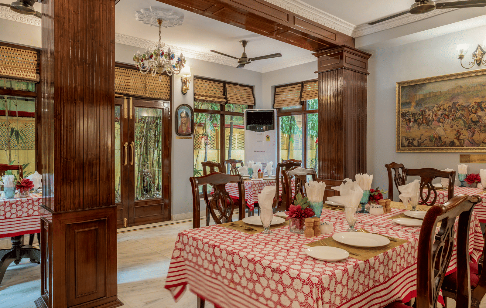 Dining space featuring wooden architecture, patterned table runners, and traditional decor at Dera Rawatsar, Jaipur.