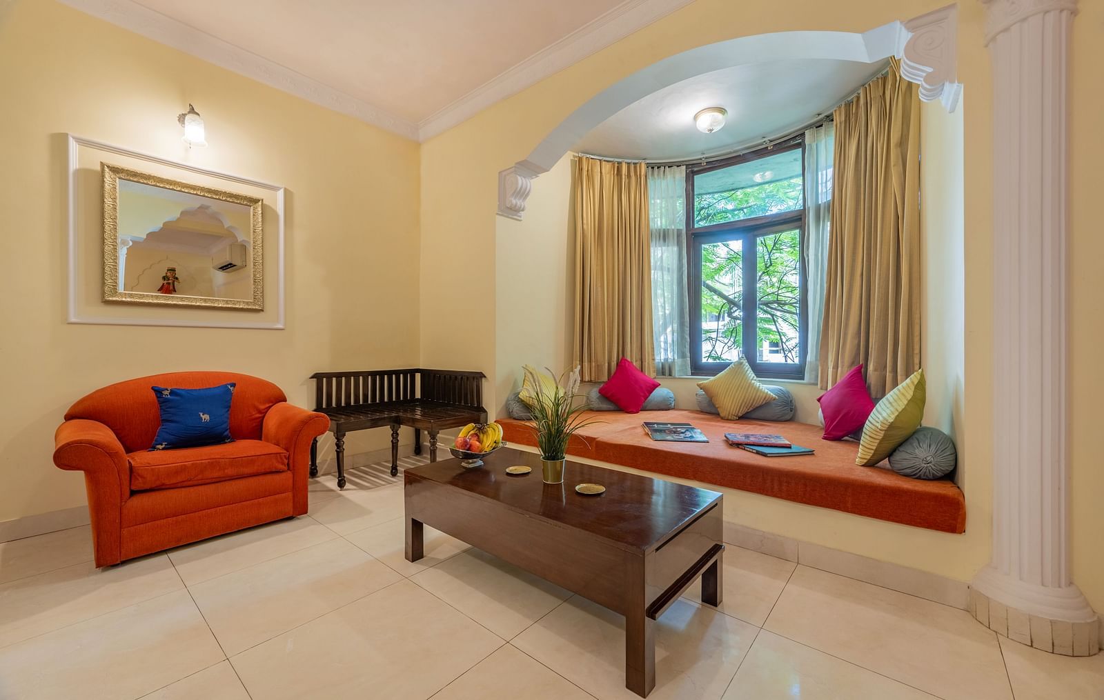 Cosy living room with a bay window, bright cushions, and warm lighting at Dera Rawatsar, Jaipur