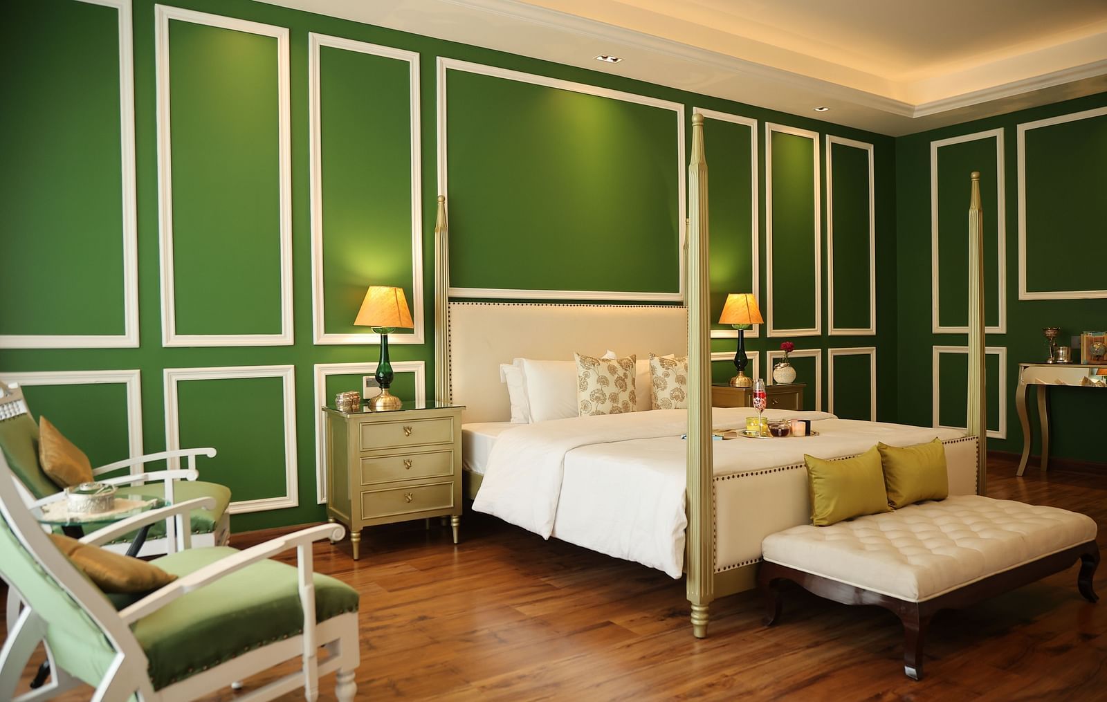 A room at Dileep Kothi, Jaipur with a double bed, side tables with night lamps and green walls