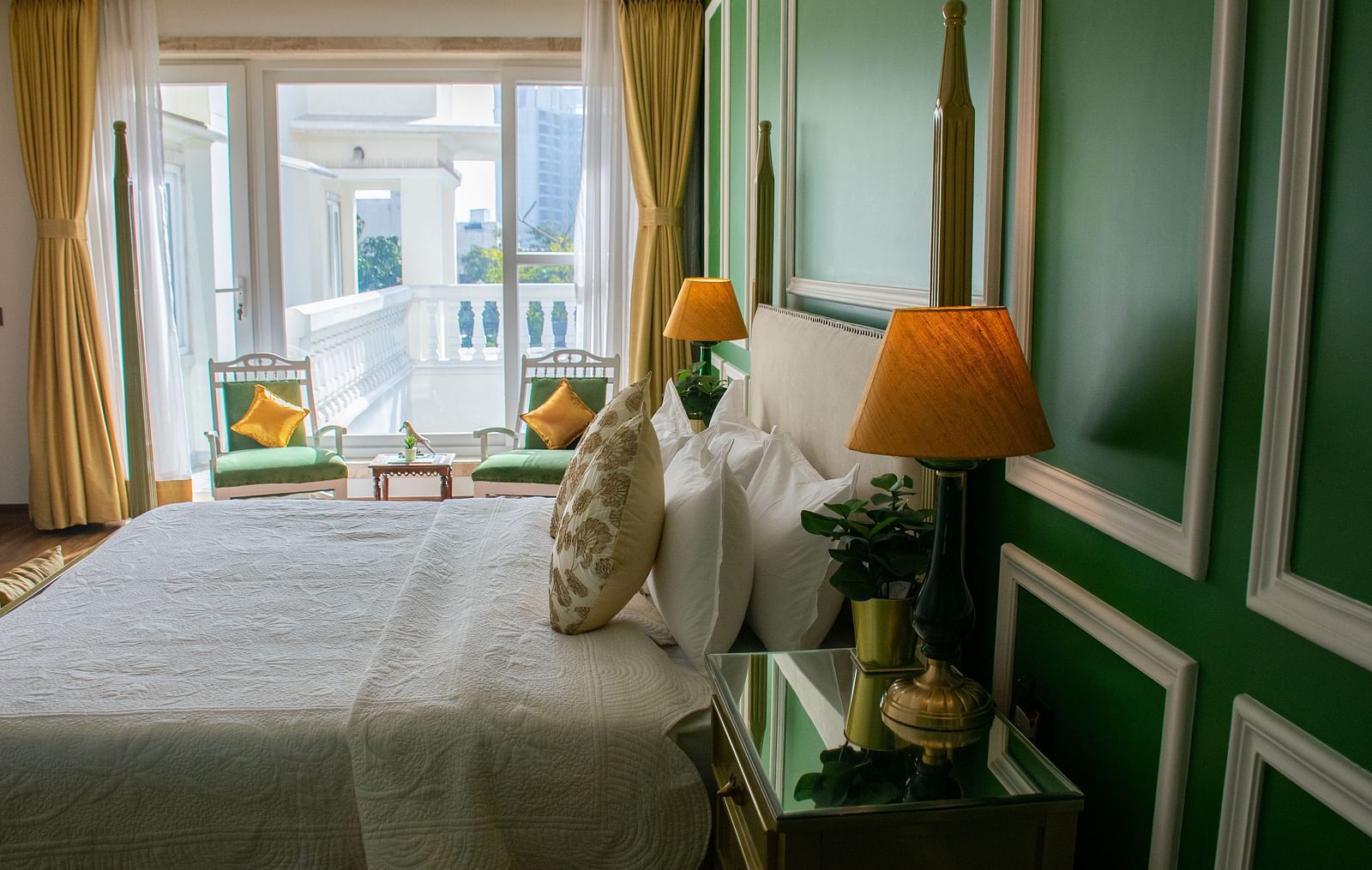 A room at Dileep Kothi, Jaipur with a double bed, side tables and a large window