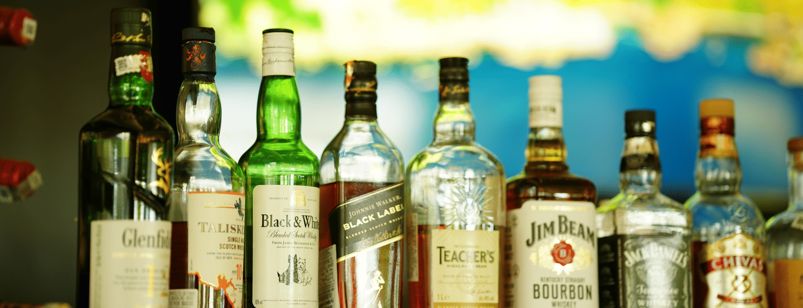 Liquor display at The Quentina Bar showcasing premium bottles arranged on a back-lit shelf - Grande Bay Resort & Spa, Mamallapuram