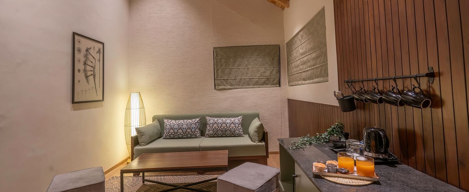 Living area with a sofa, table, and wall-mounted photographs at The Chamomile Estate.