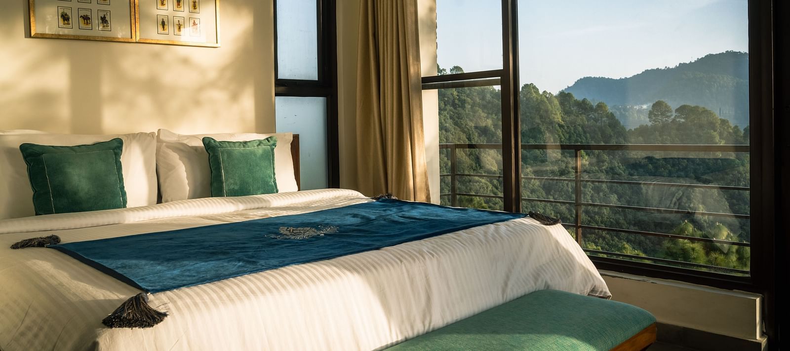 A bedroom with a balcony offering a mountain view and sunlight streaming in at BluSalzz Escapade Resort, Lansdowne