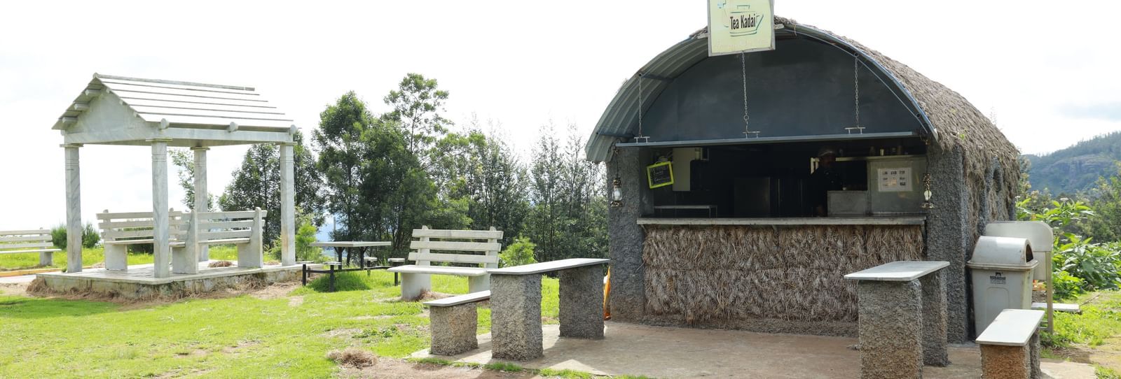 The tea shop on a manicured lawn featuring stone slabs as a seating area - Accord Highland Ooty
