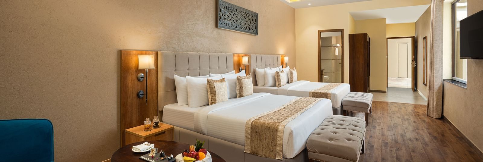 Studio Quad Room with double beds placed in front of TV at Essentia Luxury Resort & Spa, Udaipur.
