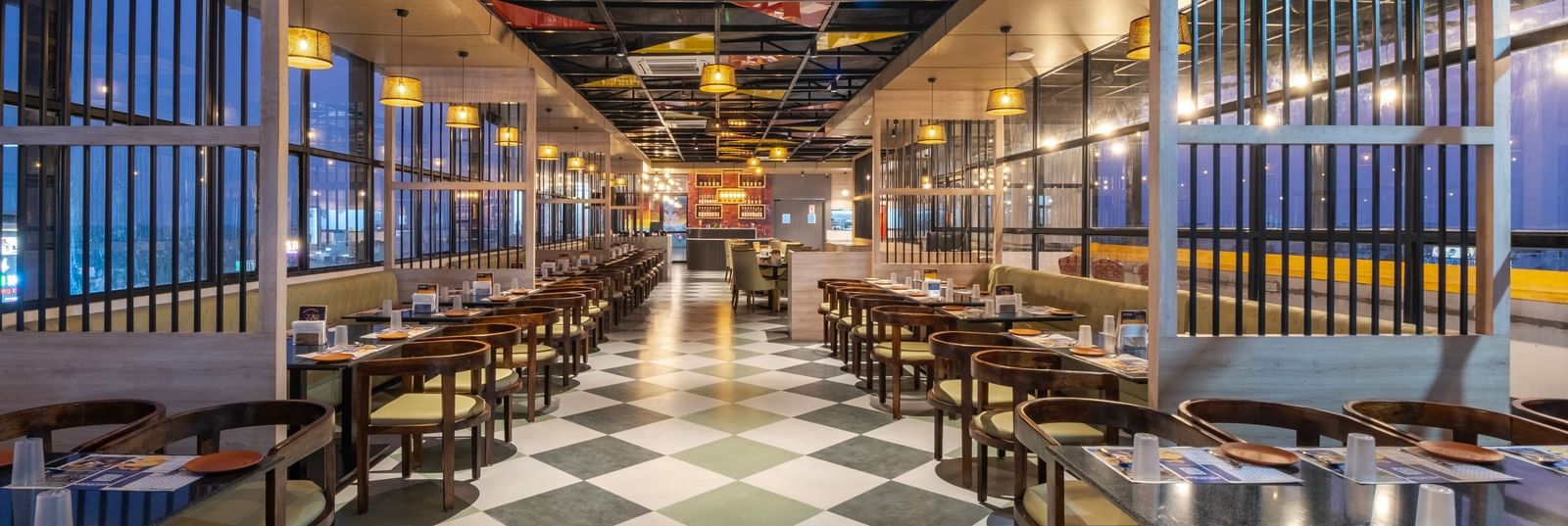 Spacious restaurant at Monday Hotels Amalapuram Heights with modern interiors and a city view.