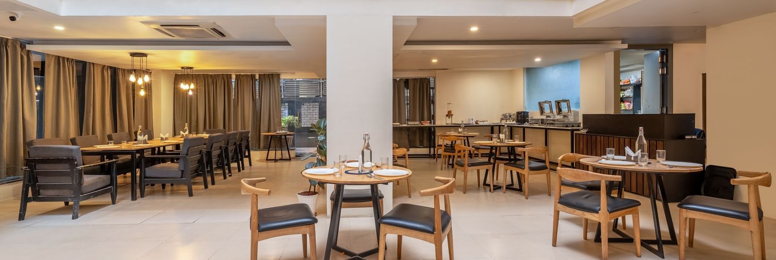 A spacious dining hall with tables and chairs neatly arranged with bright lighting - Monday Hotels HITEC City, Hyderabad