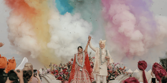 A newly wedded couple celebrating their wedding with colours flying around.