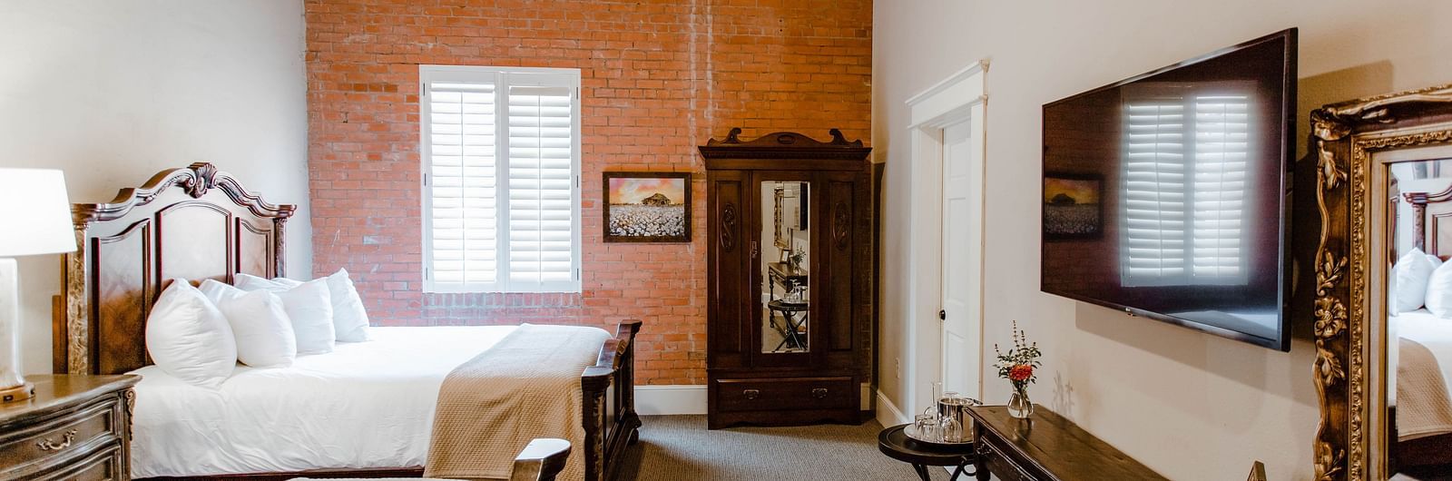 A charming bedroom with wooden furniture, elegant decor, and a ceiling fan, offering a serene and classic atmosphere - The Grand Hotel & Ballroom, McKinney