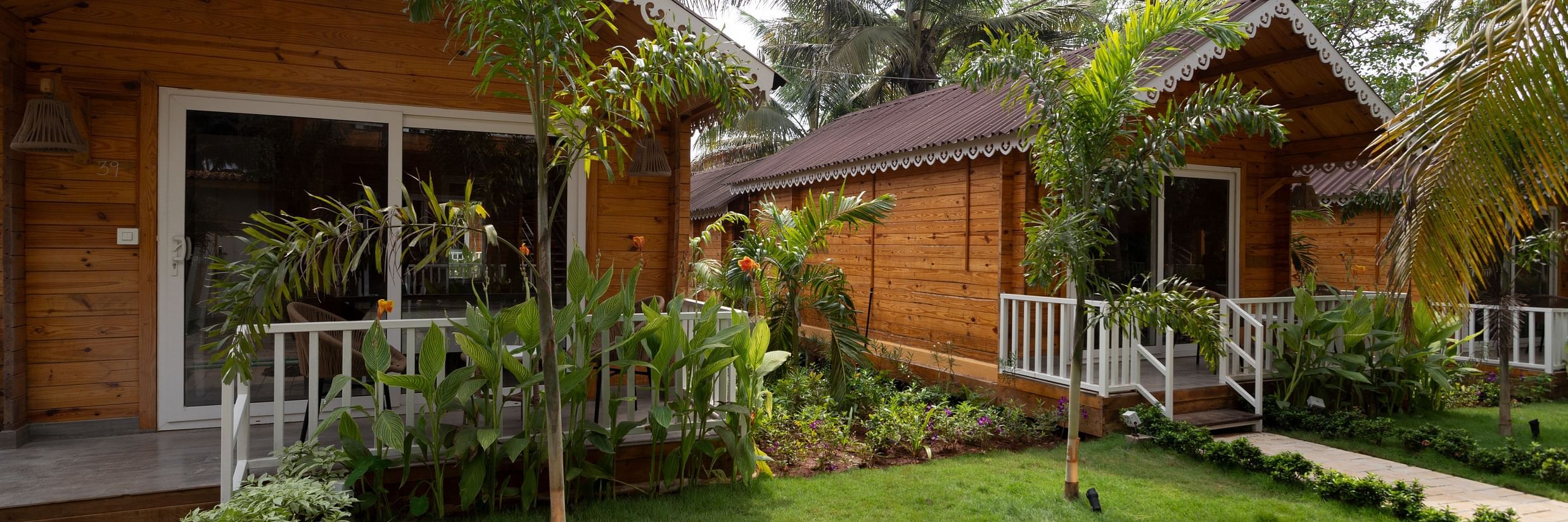 A tropical resort cabin front surrounded by lush greenery and garden pathway Aralea Beach Resort by Stone Wood, Morjim