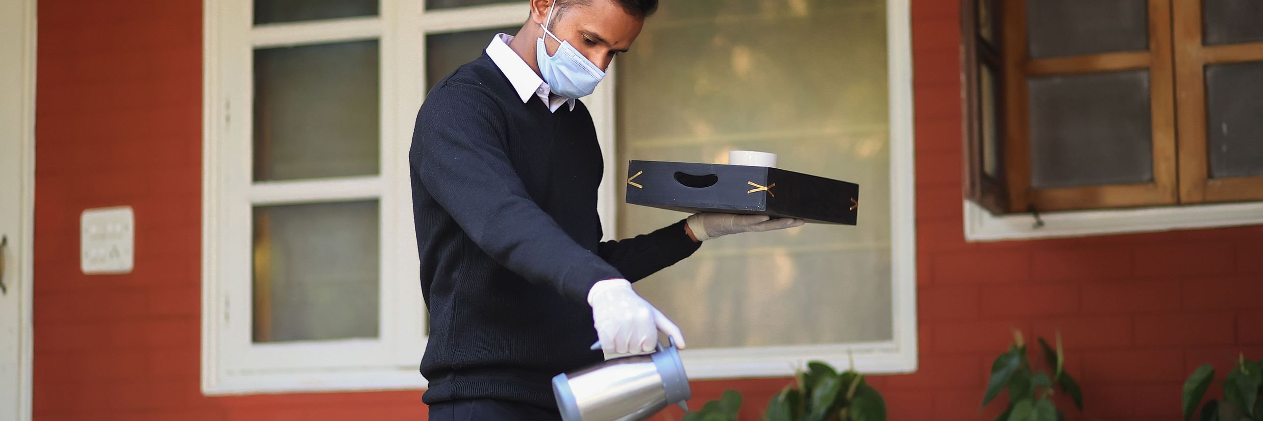 Butler pouring tea/coffee into a cup 1 - Lamrin Boutique Cottages Rishikesh
