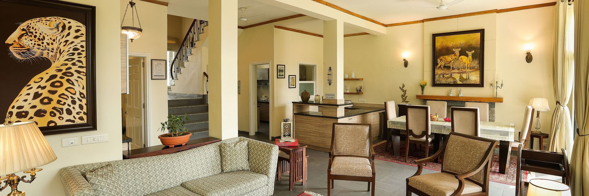 side angle view of a spacious living room with modern interior decor and large windows facing the tea gardensLiving RoomLiving Room1 - Lamrin Norwood Green Palampur